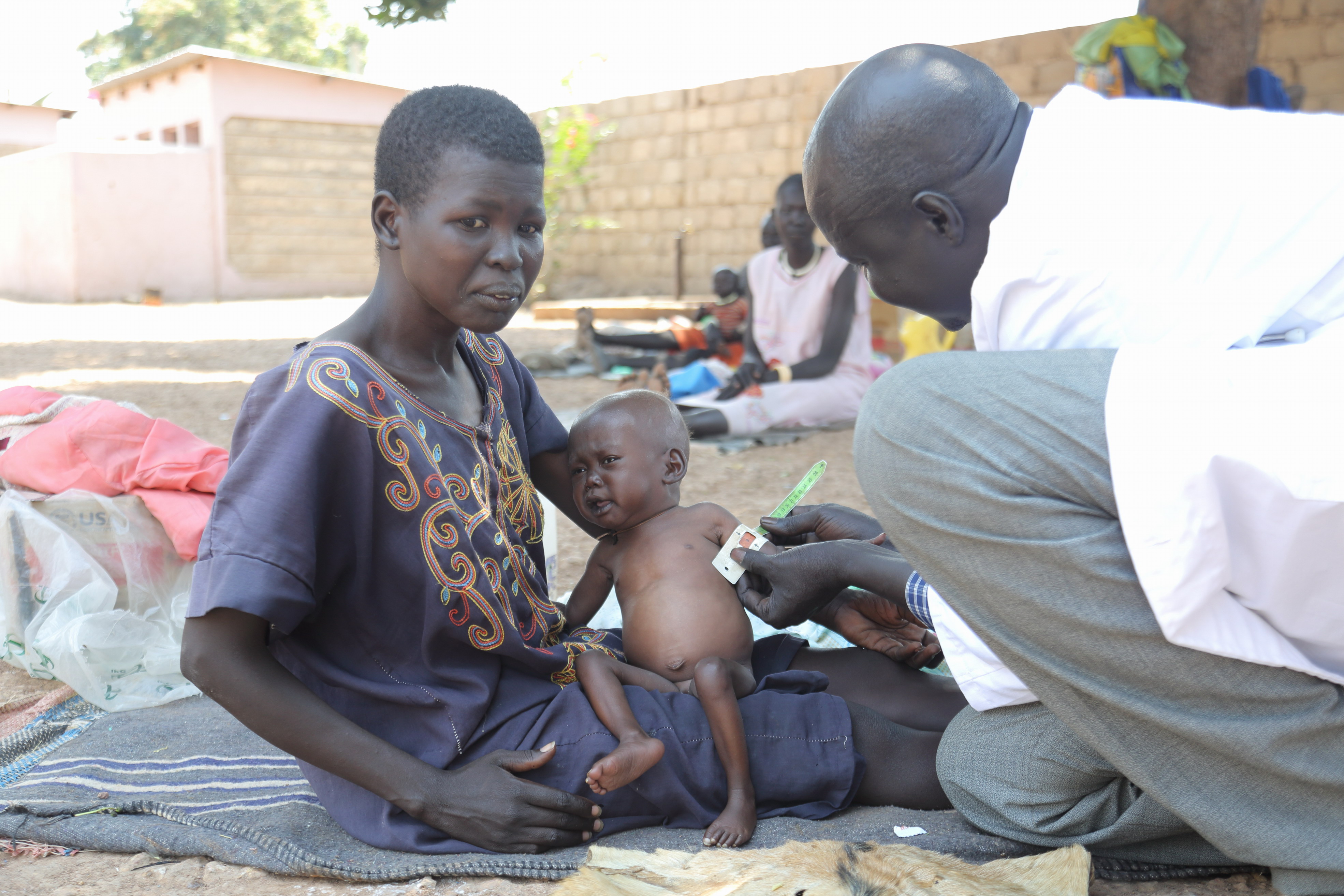 Mediziniesches Personal kümmert sich um die Kinder und Mütter, die in der Klinik Hilfe suchen. Auch die sehr geschwächte Akol wird untersucht.