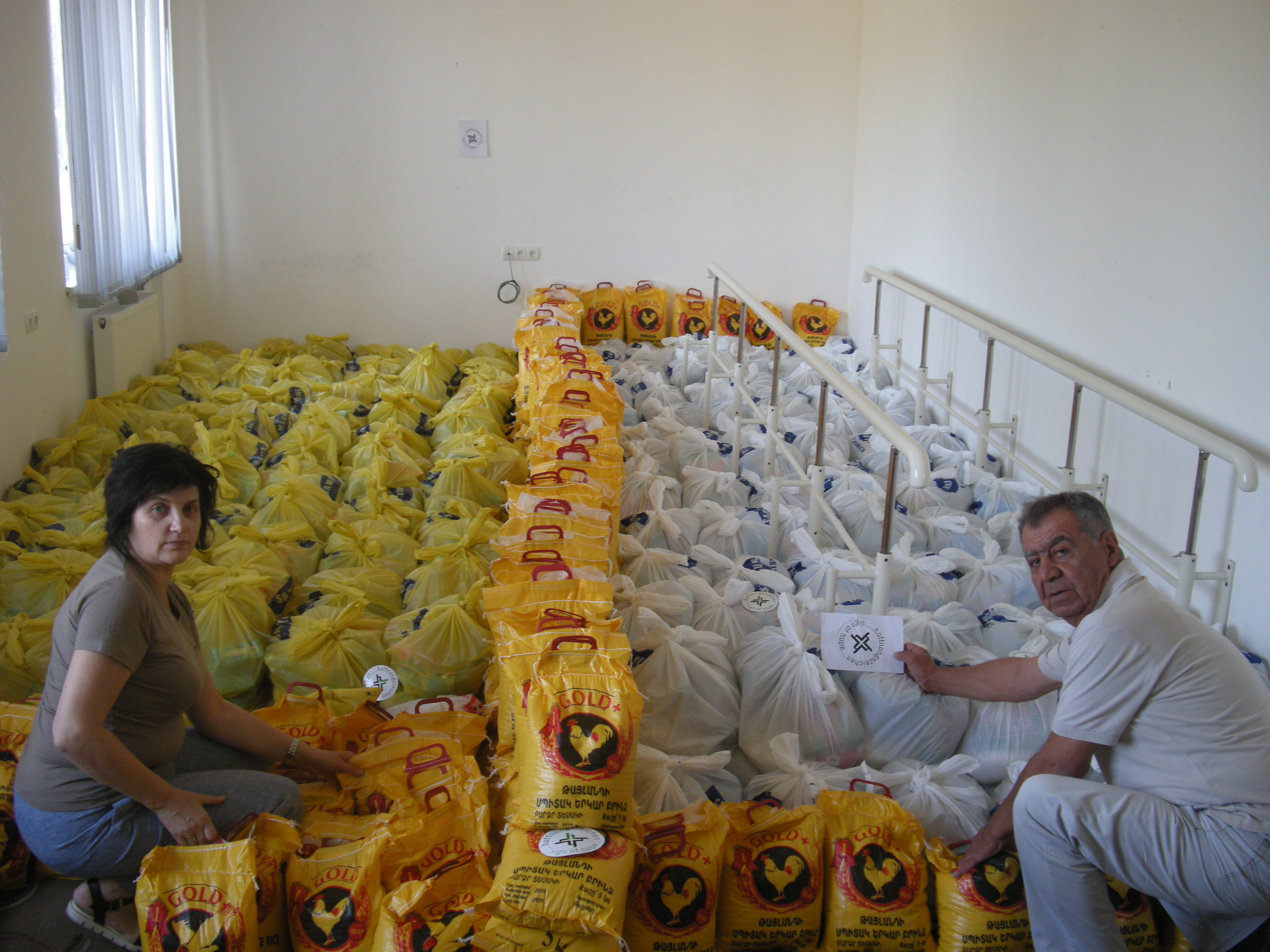 Gemeinsam mit ihrem Kollegen Wigen Aghanikjan besorgt Aljona Nahrungs- mittel, packt daraus Hilfspakete und übergibt diese an bedürftige Haushalte in  Bergkarabach.