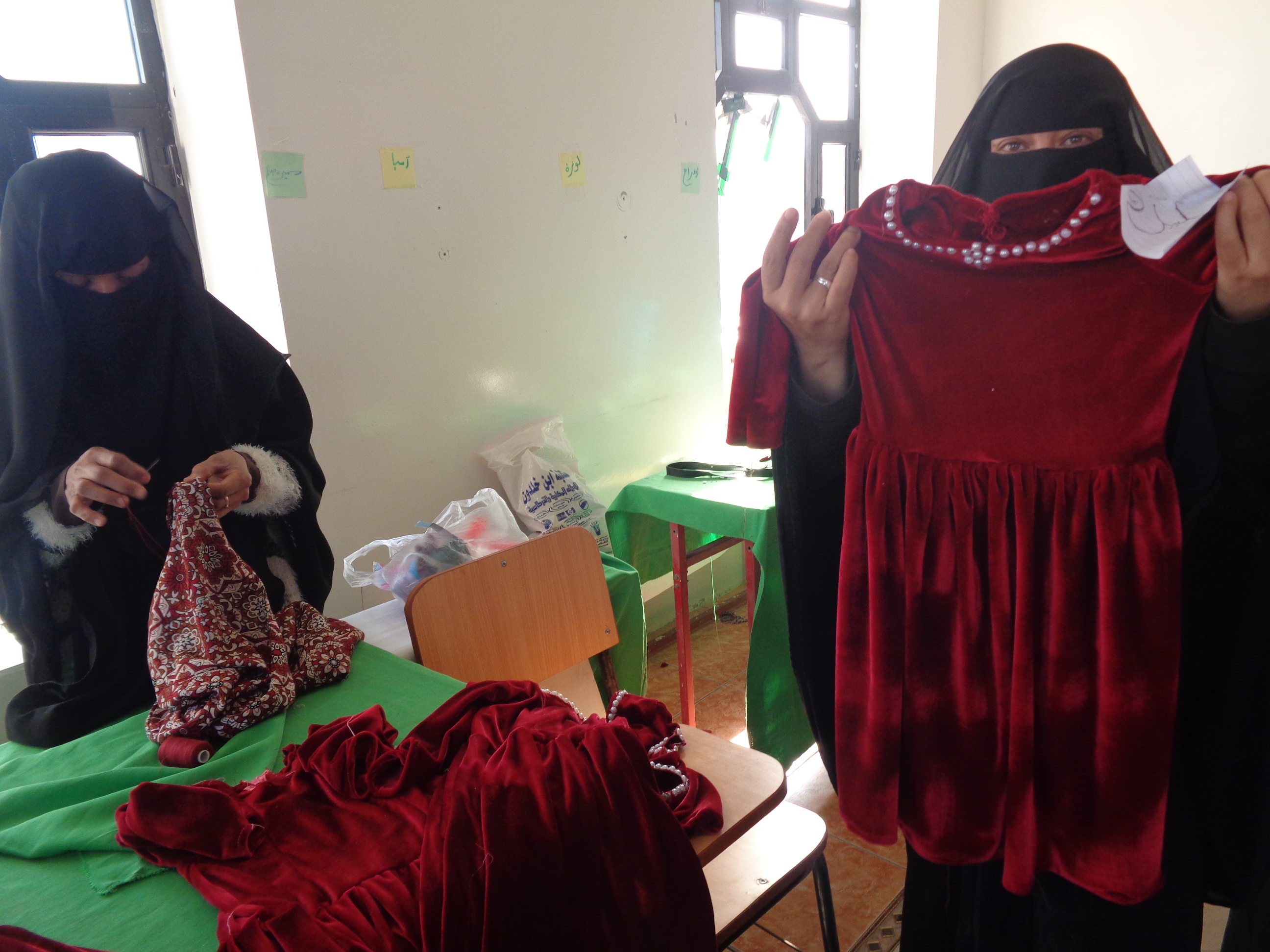 Stolz präsentiert Warda Yahya ihre neu erworbenen Nähkünste: Unter ihren geschickten Händen sind die ersten Kinderkleider entstanden. Mit dieser Arbeit kann sie jetzt für den Lebensunterhalt ihrer Familie sorgen.