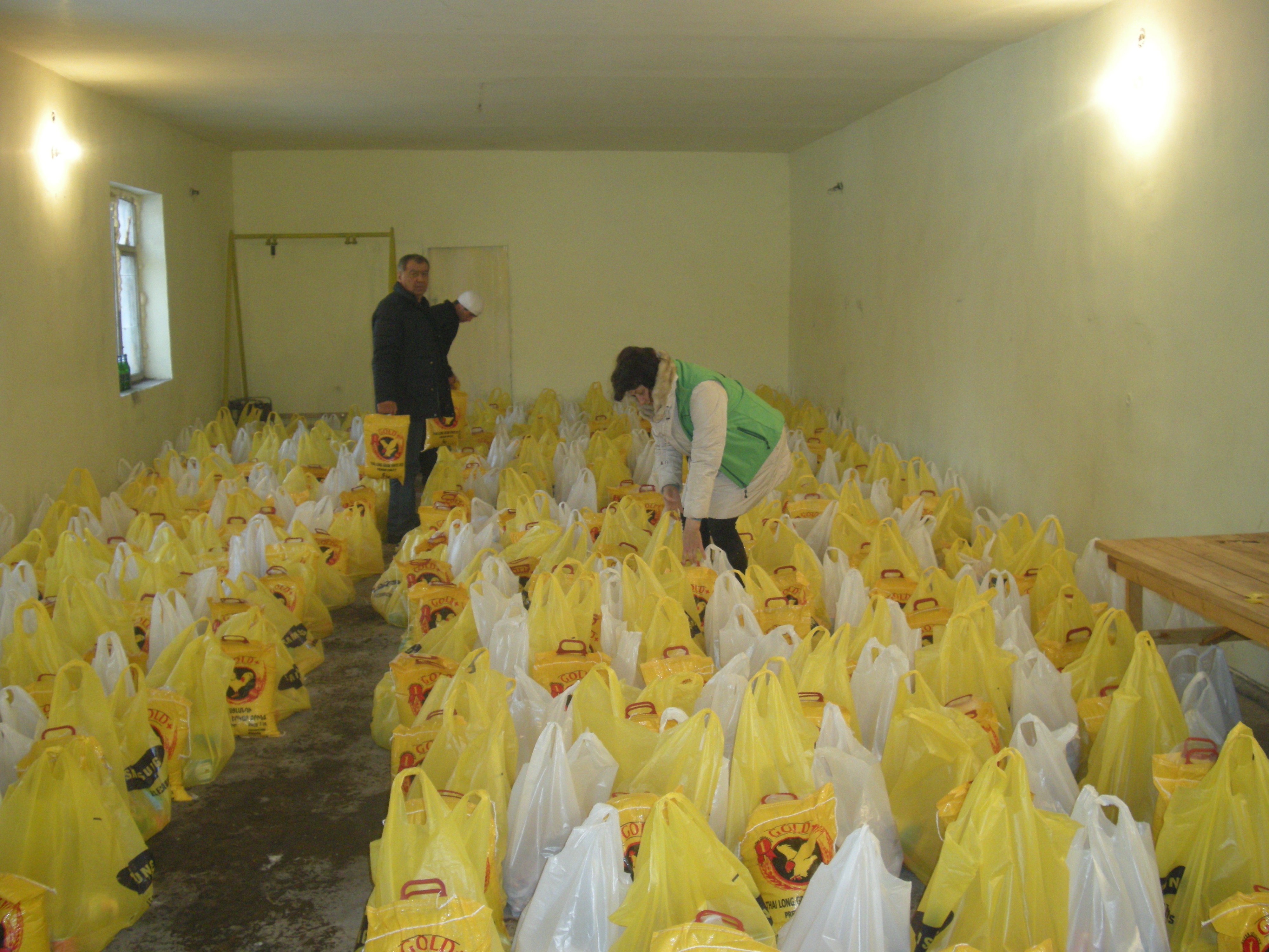 Hoffnungszeichen-Mitarbeiter Aljona Zeytunyan und Wigen Aghanikjan packen sorgsam die Lebensmittelpakete, die sie 150 besonders bedürftigen Familien übergeben möchten.