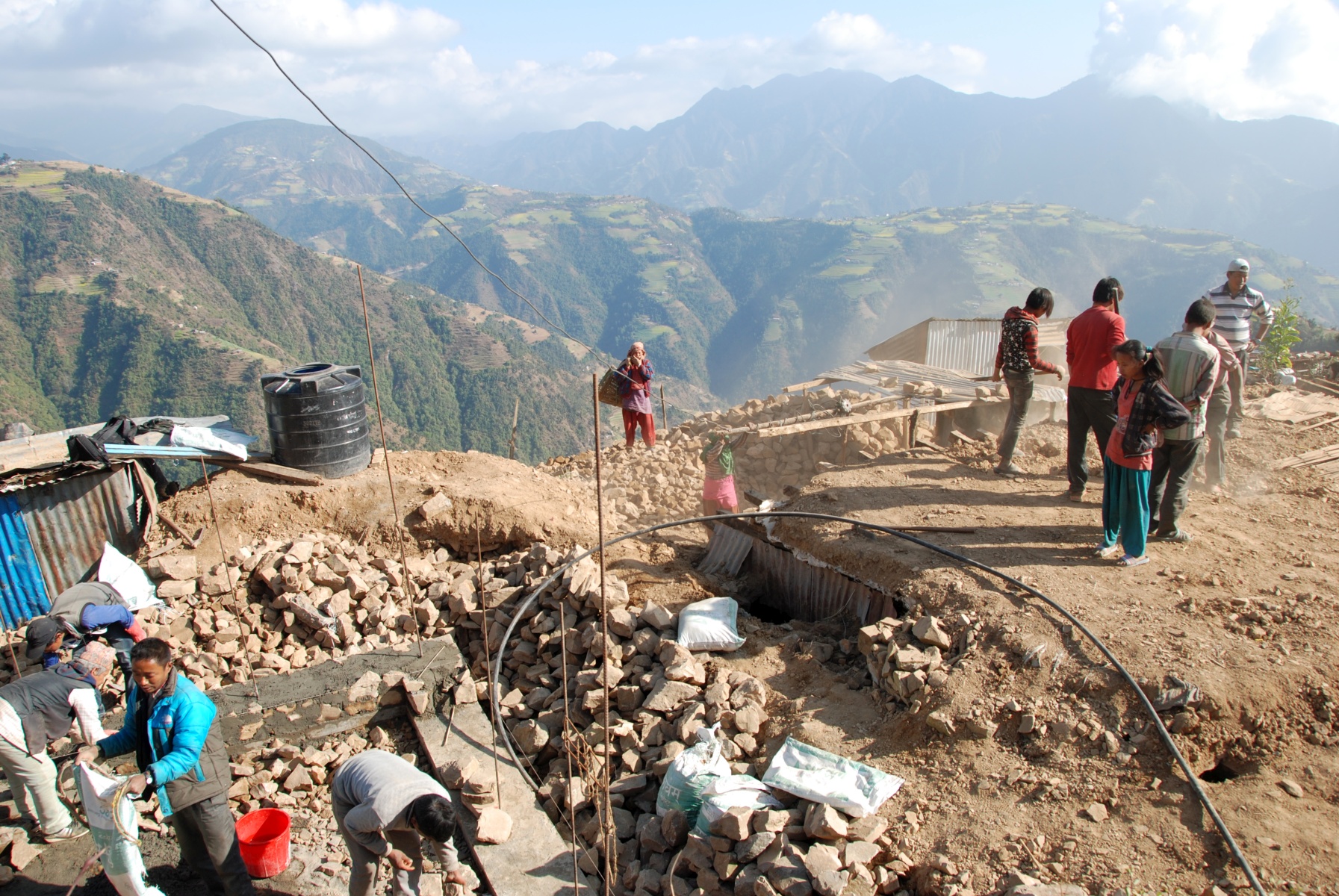 Unter Anleitung unserer Partnerorganisation und unseres Bauexperten legen die Dorfbewohner selbst beim Bau ihrer Häuser Hand an.