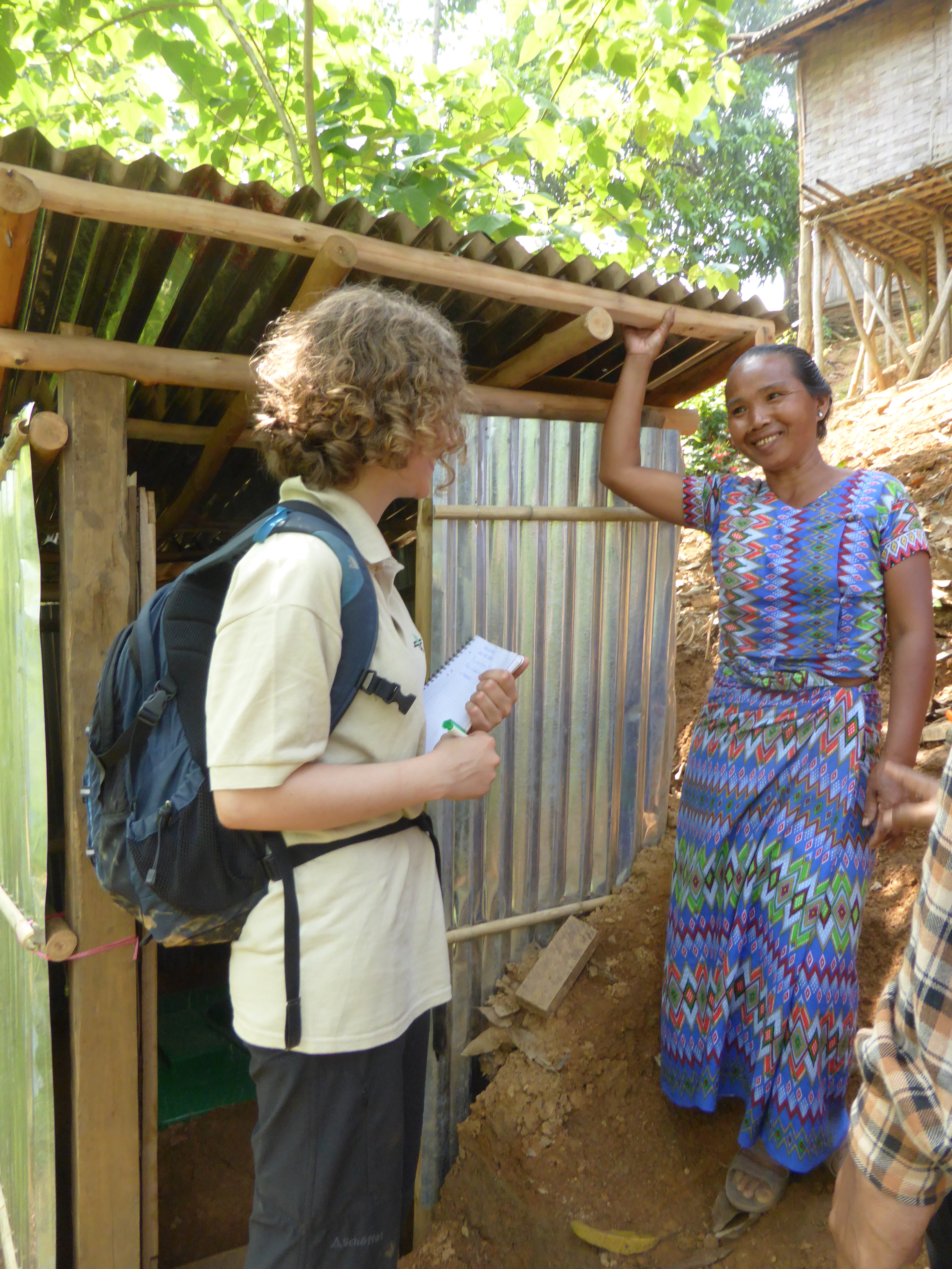 Prume (r.) ist glücklich über eine selbst gebaute Latrine. Die dafür notwendigen Materialien wurden im Rahmen des Projektes gestellt.