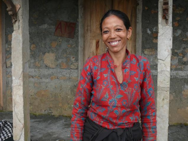 Sharmila steht stolz und glücklich vor ihrem neuen Zuhause. Wie Sharmila und Jhakendra hoffen auch andere Familien auf Unterstützung, um vor dem Wintereinbruch eine sichere Unterkunft zu erhalten.