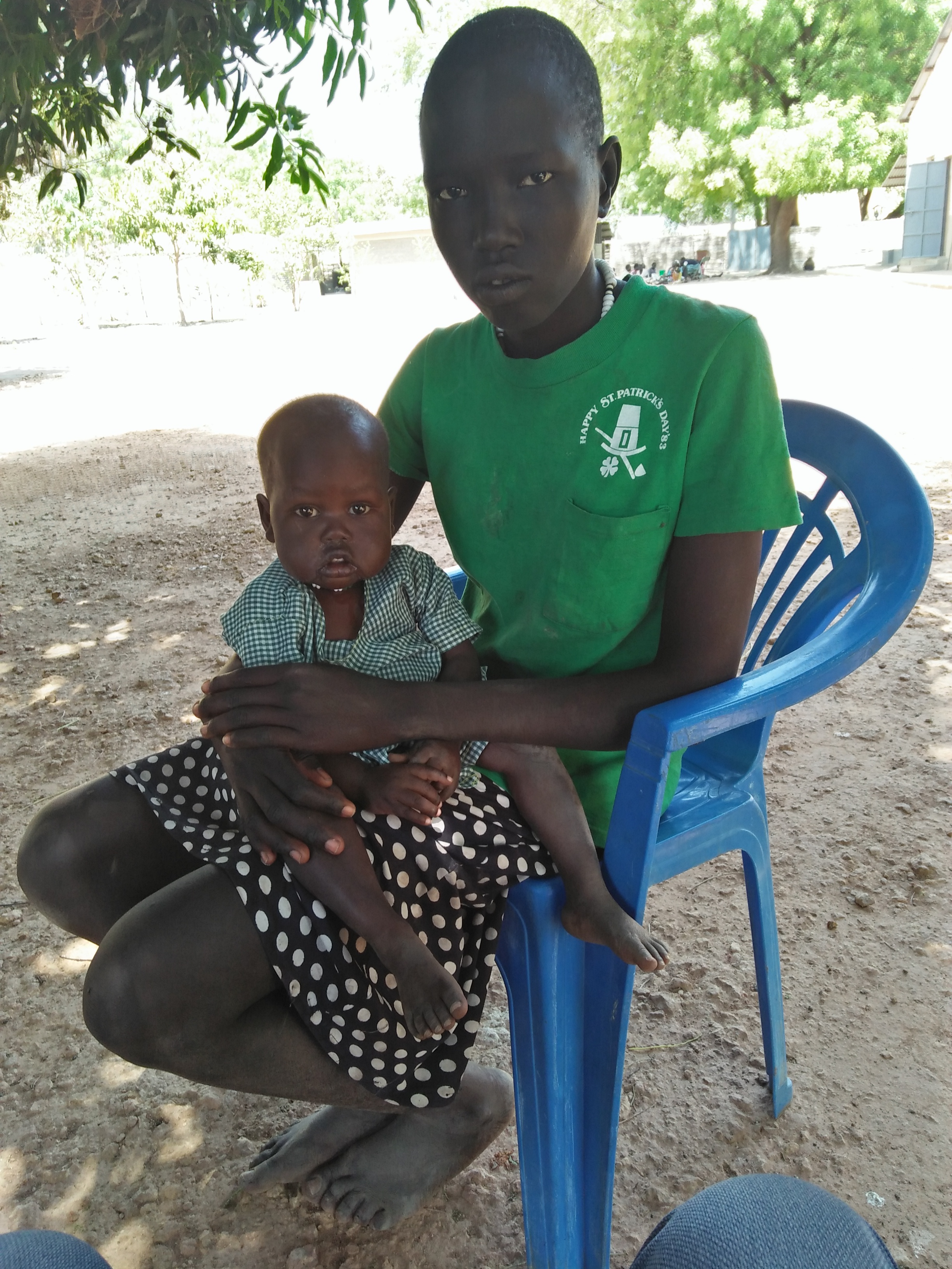 Beschützend hält die elfjährige Adeng Meen ihre kleine Schwester Amer auf dem Schoß. Ihre Mutter hat die Kinder nach dem Tod ihres Mannes aus Verzweiflung sich selbst überlassen.