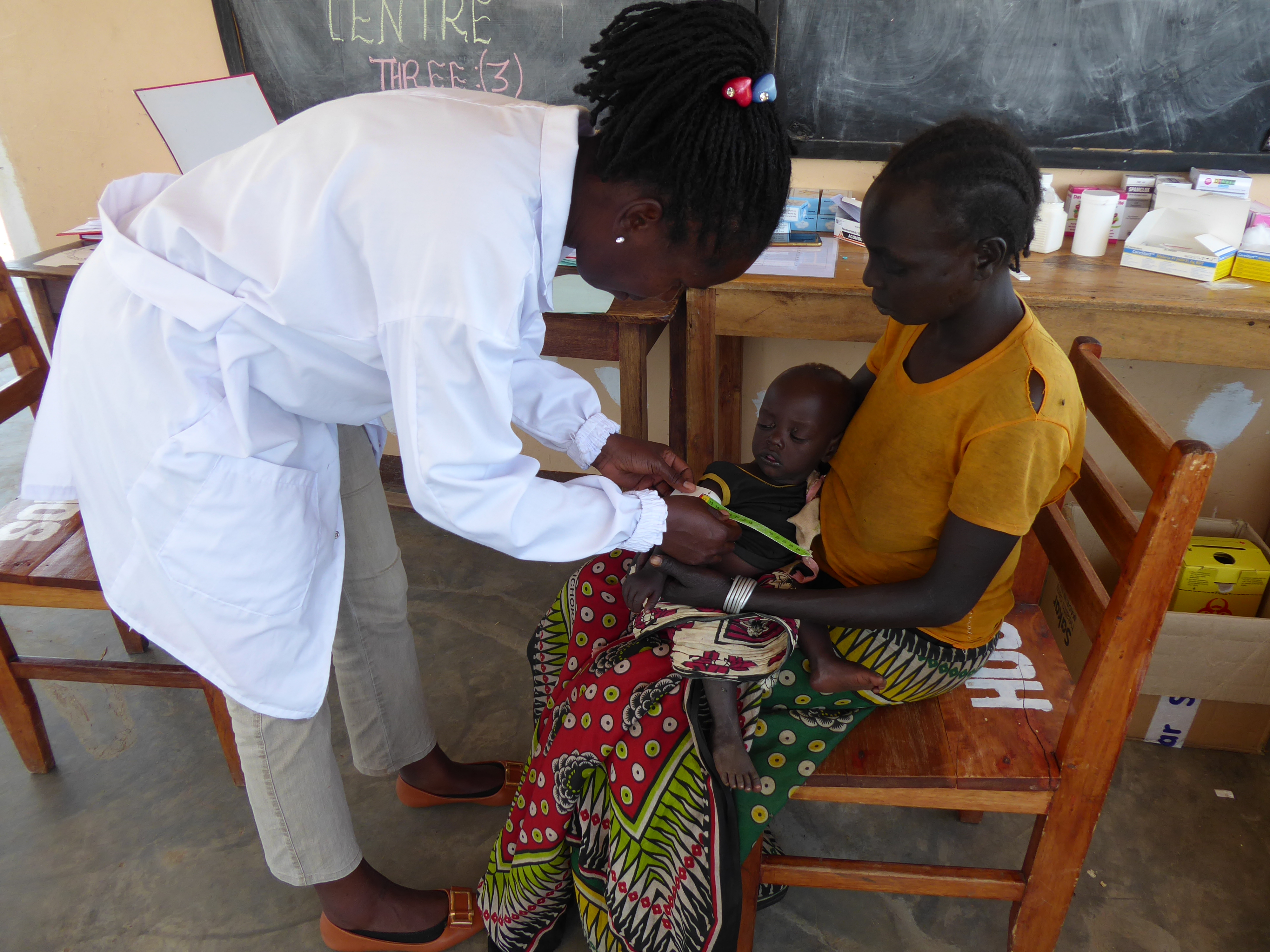 Medizinerin Cathy Aloko misst beim elf Monate alten David Krop den Oberarmumfang mit einem sog. MUAC-Bändchen. Seine Mutter hat ihn hergebracht, weil er stark an Gewicht verliert.