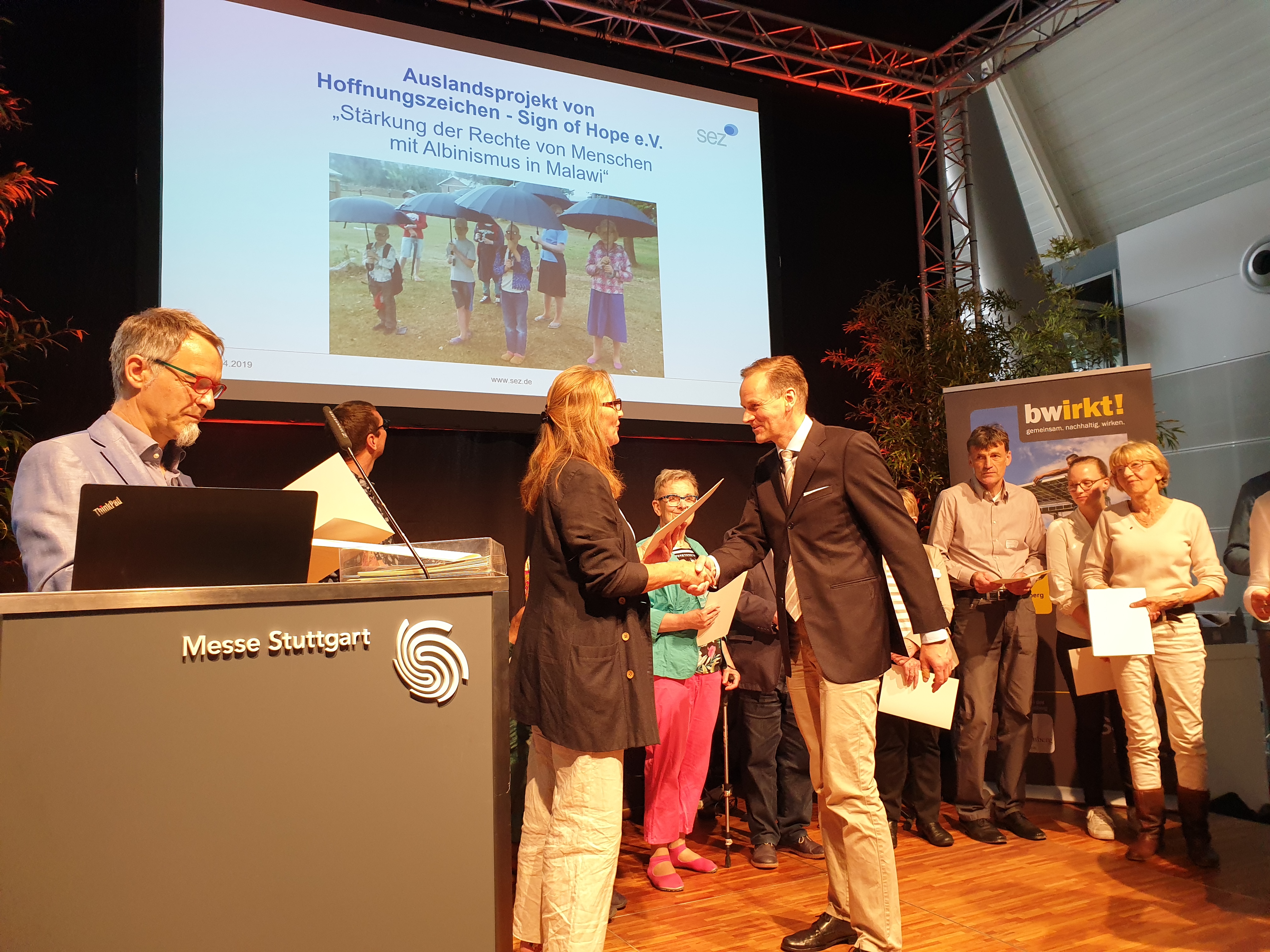 Ein Zeichen der Solidarität – Klaus Stieglitz, Zweiter Vorstand von Hoffnungszeichen, nimmt eine Auszeichnung der Stiftung Entwicklungs-Zusammenarbeit Baden-Württemberg entgegen.