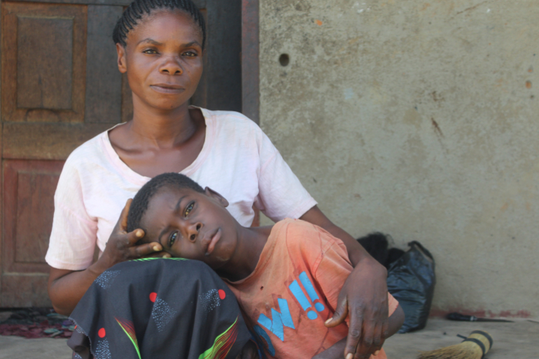 Der sechsjährige Chrisker Chibwe Mwila (auf dem Bild mit seiner Mutter) leidet unter Kopfschmerzen, Atemnot, Bauchweh und anderen Beschwerden. Untersuchungen bewiesen, dass das Kind aufgrund der hohen Bleibelastung erkrankt ist.