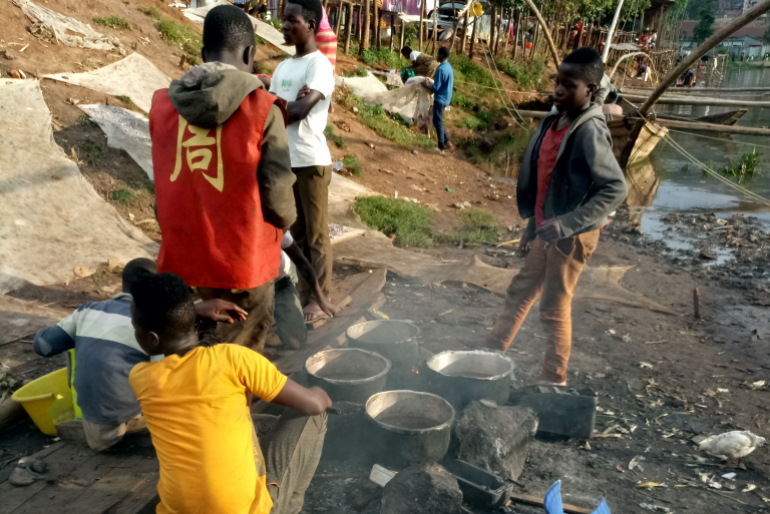 Aus dem, was die Kinder auf den Straßen Bukavus finden, erbetteln oder  stehlen konnten, bereiten sie sich an einer Kochstelle am Ufer des Kiwusees  Mahlzeiten zu.