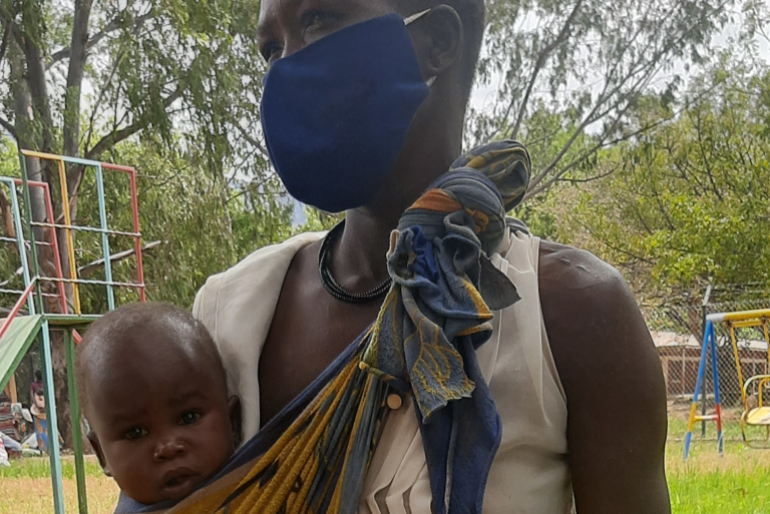 Alek mit einem ihrer Kinder: Die Frau ist krank und versorgt ihre Familie nahezu allein. Die vierfache Mutter ist sehr dankbar für das große Nahrungsmittelpa-ket, das sie von Hoffnungszeichen erhält.