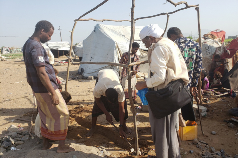 An den Eckpfeilern montierten sie dünne Baumstämme mit Draht, die als stabiles Grundgerüst dienen.