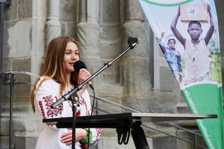 Oleksandra Berchenko, eine 15-jährige Geflüchtete, singt die ukrainische Nationalhymne.
