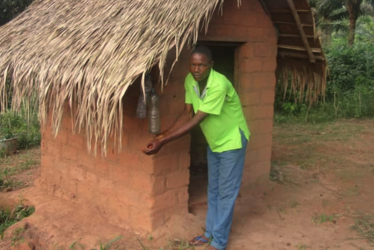 Auch Hygienemaßnahmen sind Teil des Projektes: Benois Ingoma freut sich über den Bau seiner neuen Toilette. 