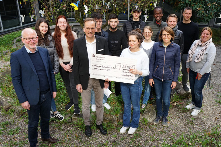 Der Schulleiter sowie zwei Lehrerinnen und Schülerinnen und Schüler der Wessenberg-Schule Konstanz übergeben dem Zweiten Vorstand von Hoffnungszeichen Klaus Stieglitz den Scheck der Sammelaktion.