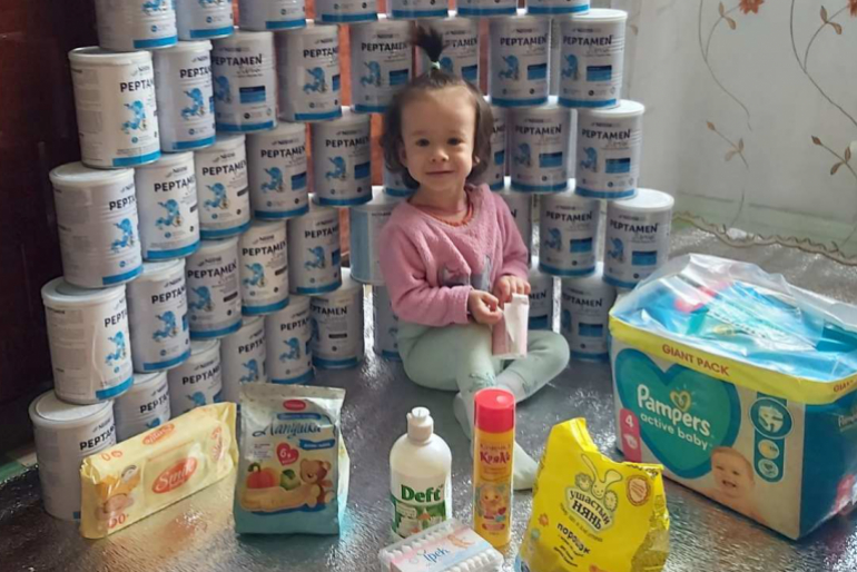 Die Familie freut sich über die Hilfsgüter. Mutter Raisa hat die Hilfsgüter für das Foto um ihre Tochter aufgestellt.