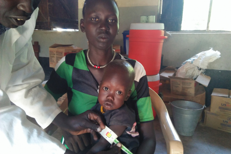 Mit einem speziellen Maßband wird an einem kleinen Patienten der Fortschritt seiner Ernährungstherapie geprüft.