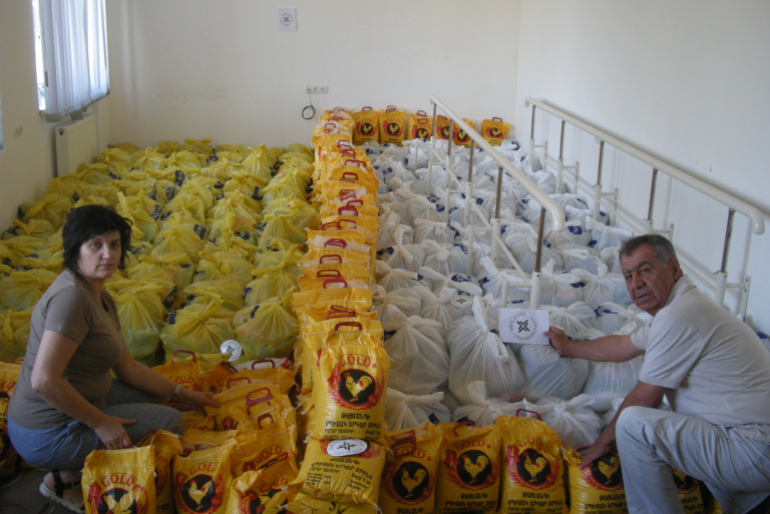 Gemeinsam mit ihrem Kollegen Wigen Aghanikjan besorgt Aljona Nahrungs- mittel, packt daraus Hilfspakete und übergibt diese an bedürftige Haushalte in  Bergkarabach.