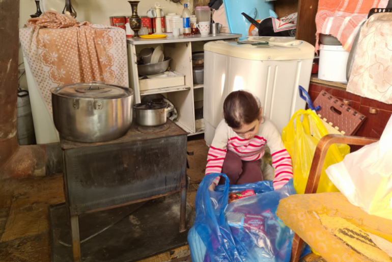 Die sechsjährige Milena Apozyan packt überglücklich das Hilfspaket von Hoffnungszeichen aus. Es enthält dringend benötigte Grundnahrungsmittel.