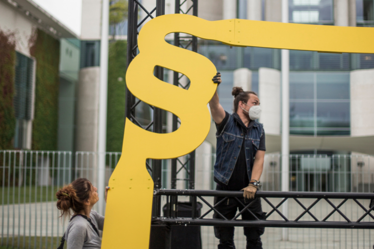 Aktivisten des bundesweiten Bündnisses „Initiative Lieferkettengesetz“ errich- ten den gesetzlichen Rahmen vor dem Bundeskanzleramt.