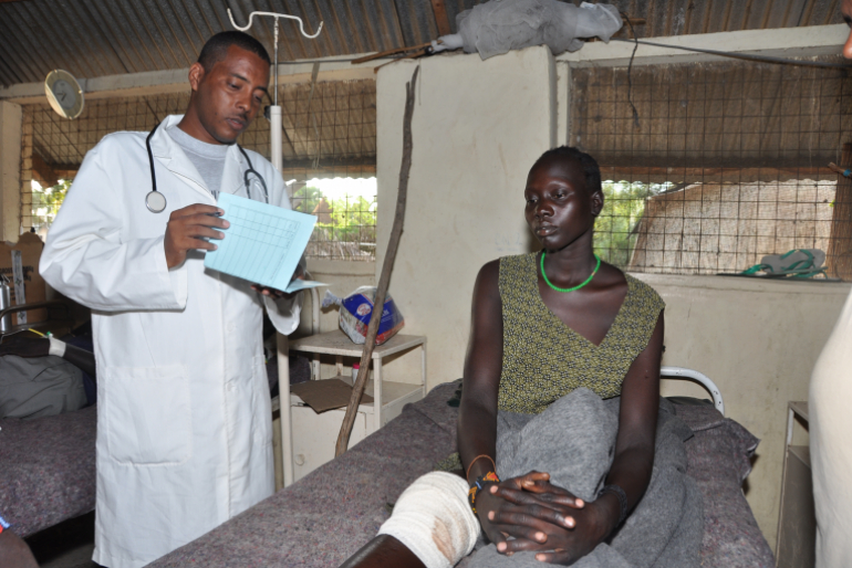 Diese Frau hat eine Verletzung am Knie erlitten. In der Krankenstation von Hoffnungszeichen kann sie einige Tage stationär behandelt werden. Der diensthabende Mediziner sieht jeden Morgen nach ihr.