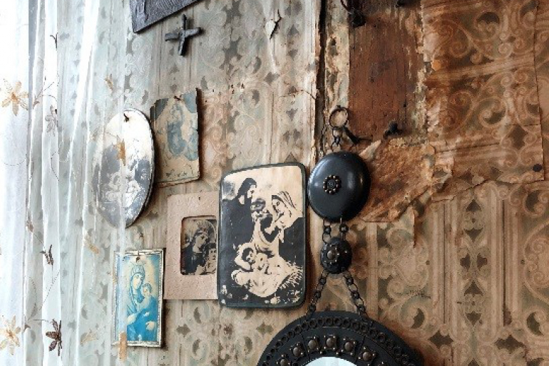 Christliche Symbole zieren die Wände vieler Dorfbewohner. Ihr unerschütterlicher Glaube schenkt ihnen Kraft und Lebensmut.