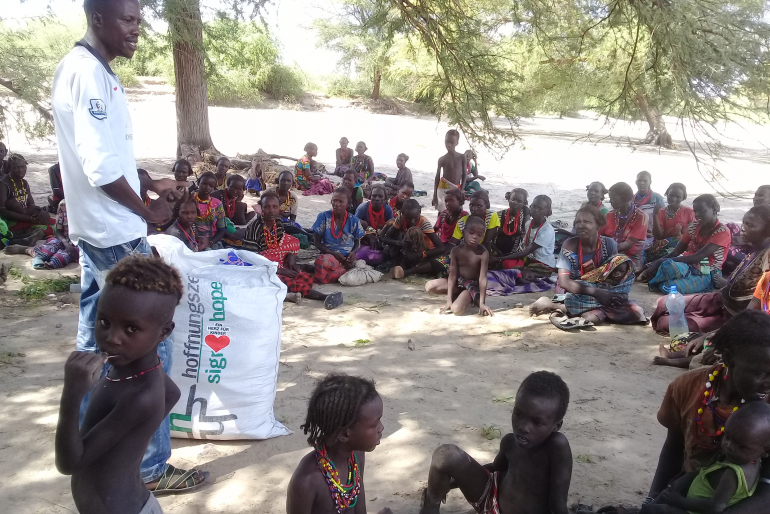 Gesundheitshelfer Nicholas Guyo gibt den Menschen bei der Ausgabe der Moskitonetze wichtige Hinweise zu Gesundheit und Hygiene. Vorsorge hilft, Krankheiten gar nicht erst aufkommen zu lassen.