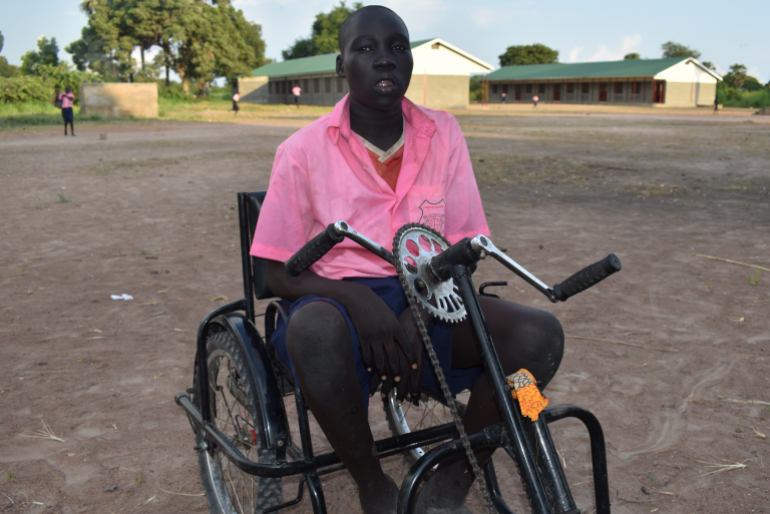 Endlich ist der Schulweg von Deng Meen (14) nicht mehr qualvoll schmerzlich. Der körperlich eingeschränkte Junge ist stolz auf sein Handfahrrad, mit dem er den Weg jetzt alleine schafft.