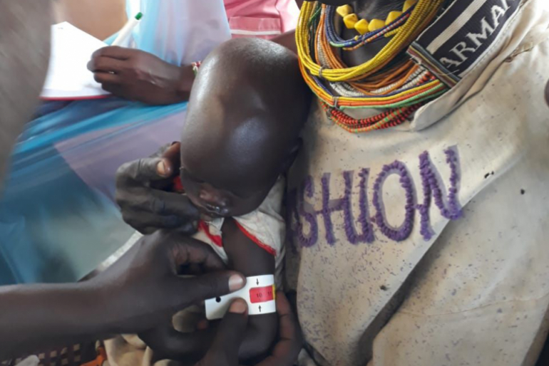 Mit dem MUAC-Band lässt sich der Ernährungszustand eines Kindes feststellen. Bei der anderthalbjährigen Rahel zeigt dieser Schnelltest einen Wert tief im roten Bereich – das Mädchen ist akut mangelernährt.