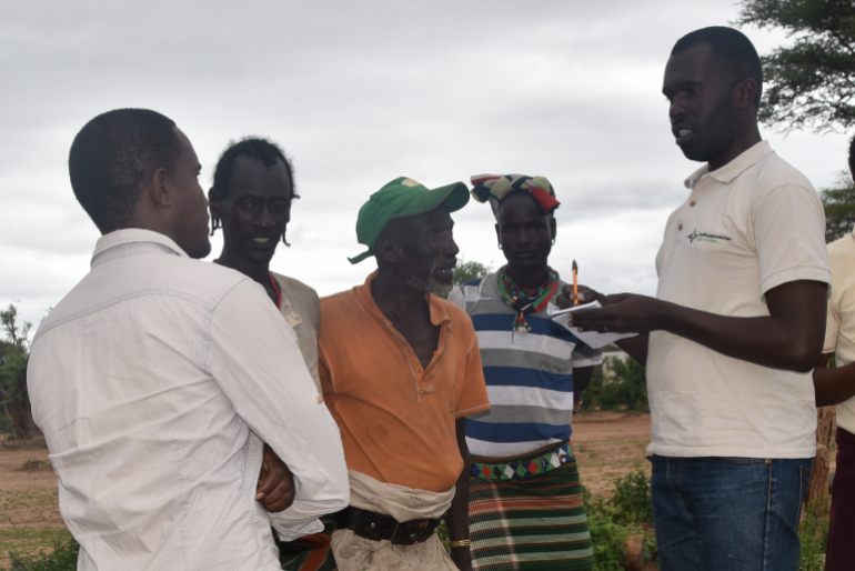 Aiko Mbali (2.v.l.) und Gili Gur (3.v.l.) berichten Hoffnungszeichen-Mitarbeiter Asher Abayo (r.) von ihren Sorgen um die Zukunft der Kinder ihres Dorfes.