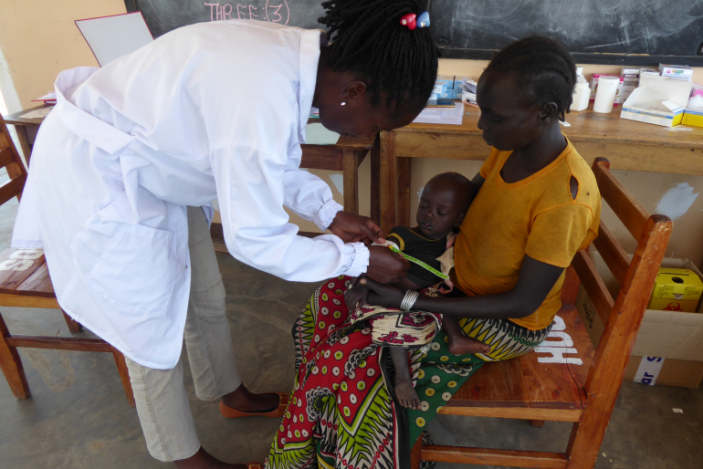 Medizinerin Cathy Aloko misst beim elf Monate alten David Krop den Oberarmumfang mit einem sog. MUAC-Bändchen. Seine Mutter hat ihn hergebracht, weil er stark an Gewicht verliert.