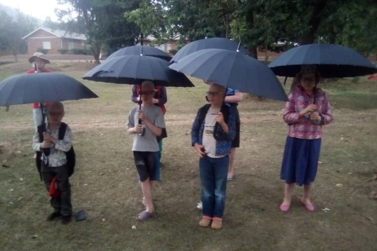 Die von Albinismus Betroffenen erhalten Schirme und Sonnenbrillen, die sie vor der starken Sonneneinstrahlung schützen.