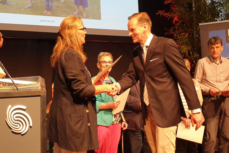 Ein Zeichen der Solidarität – Klaus Stieglitz, Zweiter Vorstand von Hoffnungszeichen, nimmt eine Auszeichnung der Stiftung Entwicklungs-Zusammenarbeit Baden-Württemberg entgegen.