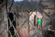 Ein Mann geht durch die Überreste eines ausgebrannten Hauses in der Nähe eines Krankenhauses in Port-au-Prince, das nach einem bewaffneten Angriff geschlossen wurde. 