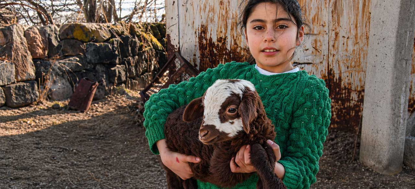 Mädchen mit Lamm auf dem Arm 