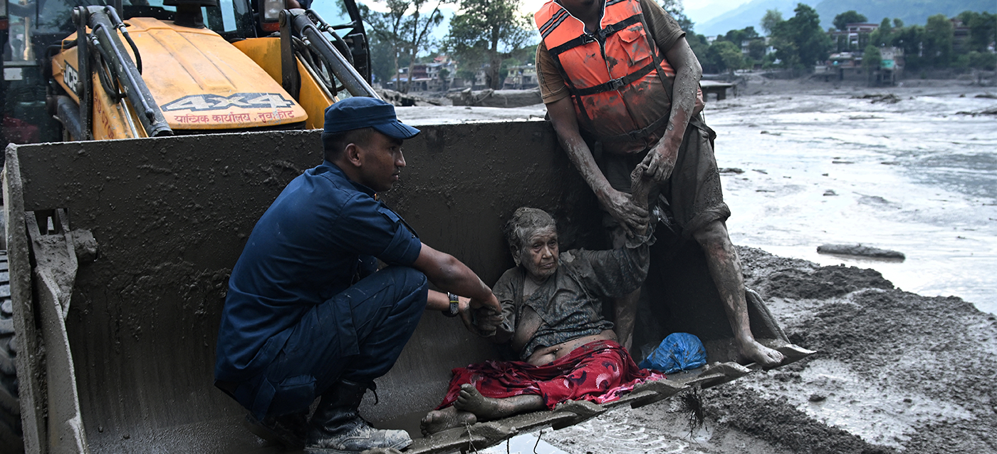 Helfer helfen einem Opfer der Sturzflut in Nepal 
