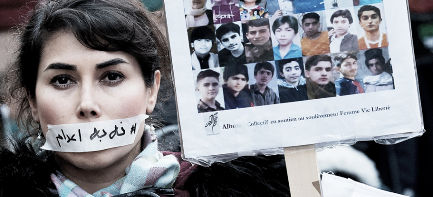 Eine Demonstrantin trägt am 31. Januar in Paris einen Aufkleber mit der Aufschrift „Keine Hinrichtung” über ihrem Mund, neben den Porträts mutmaßlicher Opfer von Razzien im Iran.