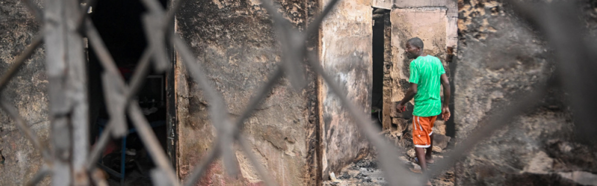 Ein Mann geht durch die Überreste eines ausgebrannten Hauses in der Nähe eines Krankenhauses in Port-au-Prince, das nach einem bewaffneten Angriff geschlossen wurde. 