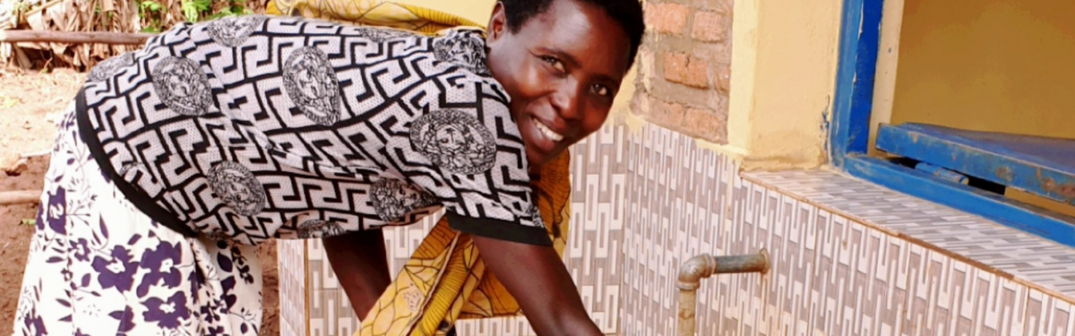 Frau holt Wasser am Wasserkiosk