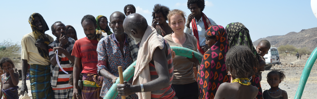 Hoffnungszeichen-Mitarbeiterin Pia Göser freut sich mit den Dorfbewohnern über das frische Wasser, das aus dem Tanklaster fließt.