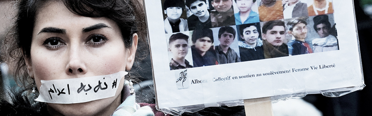 Eine Demonstrantin trägt am 31. Januar in Paris einen Aufkleber mit der Aufschrift „Keine Hinrichtung” über ihrem Mund, neben den Porträts mutmaßlicher Opfer von Razzien im Iran.