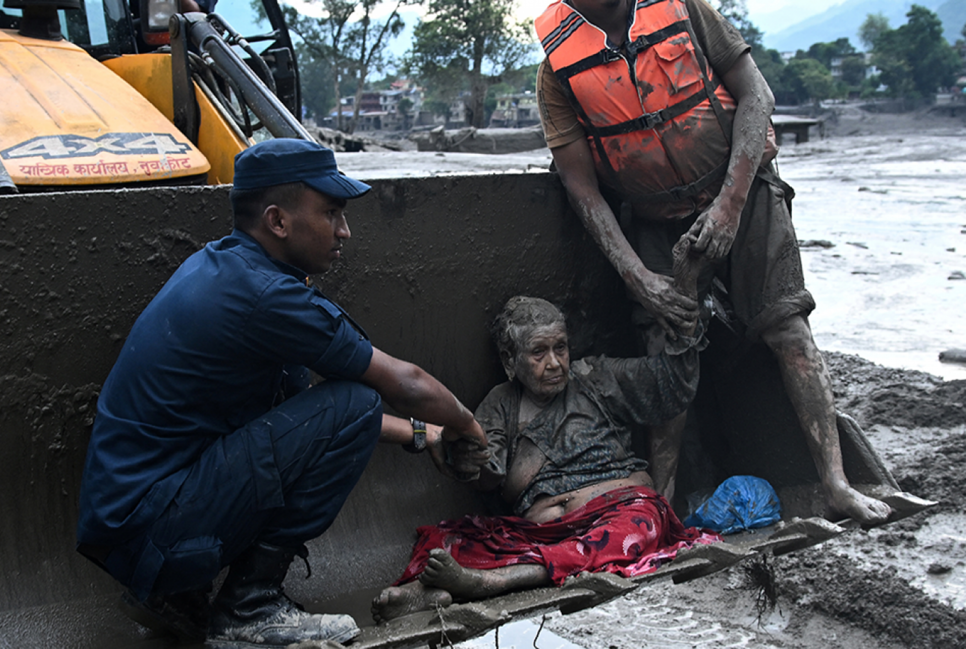 Helfer helfen einem Opfer der Sturzflut in Nepal 